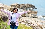 Woman Standing Arms Out On The Rock Stock Photo