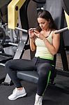 Woman Using Mobile Phone On A Break In Health Club Stock Photo