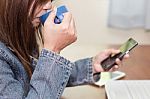 Woman Using Smartphone While Drinking Coffee Stock Photo