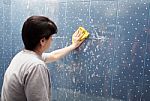 Woman Washing Tile On The Wall With A Cloth Lather Stock Photo