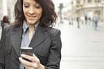 Woman With Cellphone Walking On Street Stock Photo