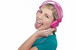 Woman With Headphones On Sticking Her Pierced Tongue Out Stock Photo