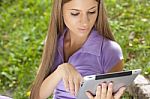 Woman With Tablet Computer In Park Stock Photo