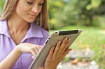 Woman With Tablet Computer In Park Stock Photo