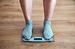 Woman's Legs Standing On The Scales Stock Photo