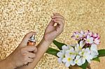 Women Hand Spraying Perfume At Wrist With Flowers In Vase And Cl Stock Photo