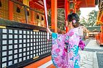 Women In Traditional Japanese Kimonos At Fushimi Inari Shrine In Kyoto, Japan Stock Photo