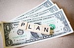 Wooden Block Word Plan And Dollar Banknote Stock Photo