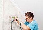 Worker Painting Wall With Background Glue For A Wallpaper Stock Photo