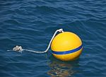 Yellow Buoy Floating On Blue Sea Stock Photo