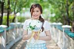 Young Asian Cute Woman Smelling White Flowers Stock Photo