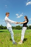 Young Attractive Couple Holding Each Other In Sunny Meadow Stock Photo