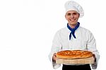 Young Baker Holds A Loaf On Breadboard Stock Photo