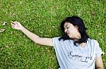 Young Beautiful Asian Laying On The Grass Stock Photo