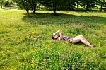 Young Beautiful Brunette Lying On The Grass Stock Photo