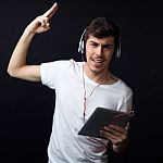 Young Beautiful Man Listening To Music. Isolated On Black Stock Photo