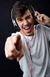 Young Beautiful Man Listening To Music. Isolated On Black Stock Photo