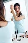 Young Beautiful Woman Making Hairstyle Near Mirror Stock Photo