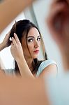 Young Beautiful Woman Making Hairstyle Near Mirror Stock Photo