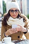 Young Beautiful Woman Using Her Mobile Phone In A Cafe Stock Photo