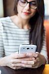 Young Beautiful Woman Using Her Mobile Phone In Coffee Stock Photo