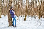 Young Beautiful Woman Walking Under A Snowfall Stock Photo