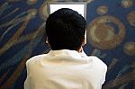 Young Boy Lying On The Floor Working On His Computer Stock Photo