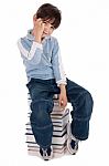 Young Boy Sitting Over Tower Of Books Stock Photo