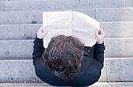 Young Business Man Reading A Newspaper Viewed From Above Stock Photo