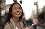 Young Business Women With Cell Phone Looking At Someone Stock Photo