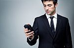 Young Businessman Looking At Smartphone Stock Photo