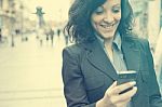 Young Businesswoman With Smartphone Walking On City Stock Photo