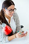 Young Businesswoman Working In Her Office With Mobile Phone Stock Photo