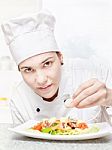 Young Chef Decorating Delicious Salad Stock Photo