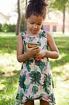 Young Child Using Smartphone At Park Stock Photo