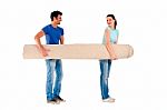 Young Couple Carrying A Carpet Stock Photo