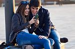 Young Couple Of Tourist In Town Using Mobile Phone Stock Photo