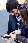 Young Couple Of Tourist In Town Using Mobile Phone Stock Photo