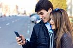 Young Couple Of Tourist In Town Using Mobile Phone Stock Photo