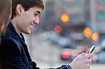 Young Couple Of Tourist In Town Using Mobile Phone Stock Photo