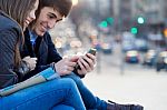 Young Couple Of Tourist In Town Using Mobile Phone Stock Photo