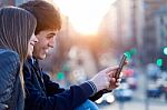 Young Couple Of Tourist In Town Using Mobile Phone Stock Photo