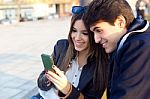 Young Couple Of Tourist In Town Using Mobile Phone Stock Photo