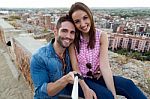 Young Couple Of Tourist In Town Using Mobile Phone Stock Photo