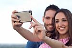 Young Couple Of Tourist In Town Using Mobile Phone Stock Photo