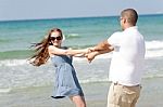 Young Couple Playing On Beach Stock Photo