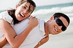 Young Couple Playing On Beach Stock Photo