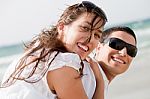 Young Couple Playing On Beach Stock Photo