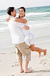 Young Couple Playing On Beach Stock Photo