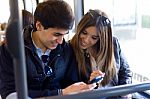 Young Couple Using Mobile Phone At Bus Stock Photo